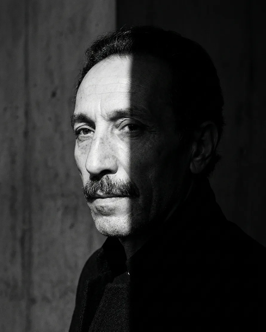 Black-and-white portrait of Father Tanrıverdi, half in shadow.